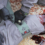 TX3 ratcheting tourniquet applied to leg, showing wide 3-inch band securing limb with advanced ratcheting mechanism